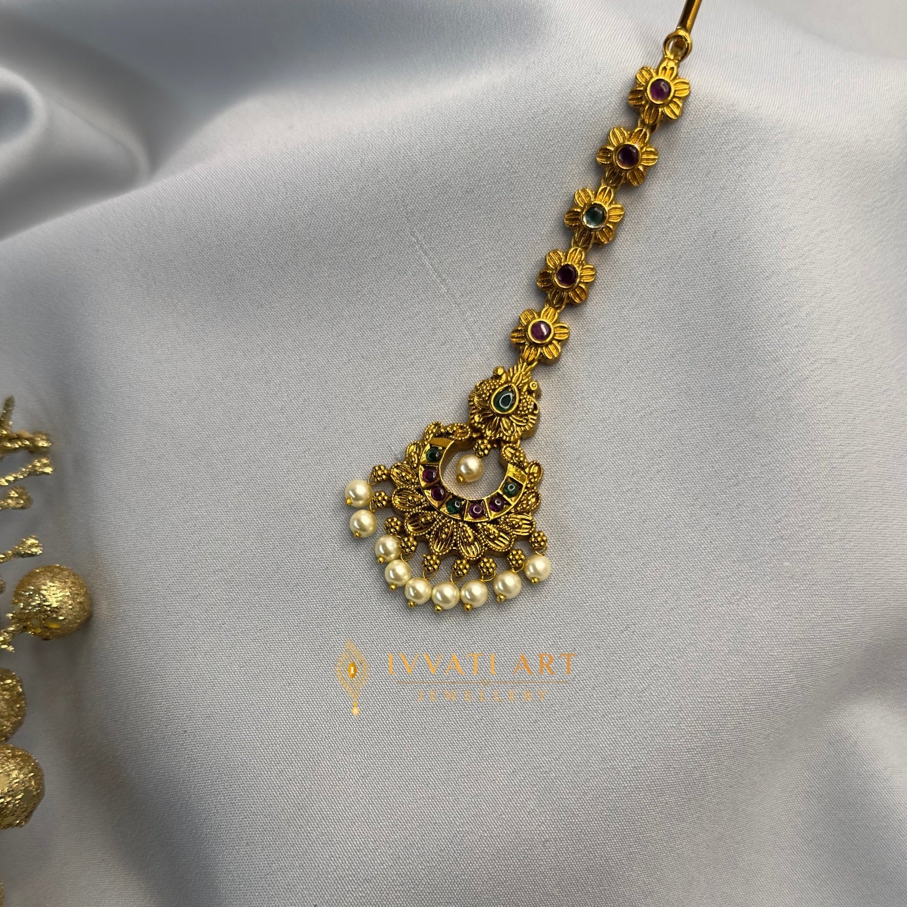 Antique gold maang tikka with floral design, multicolor stones, and pearl drops – handcrafted by Ivvati Art Jewellery.