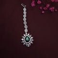 Close-up of emerald green stone center with surrounding crystal halo in maang tikka design