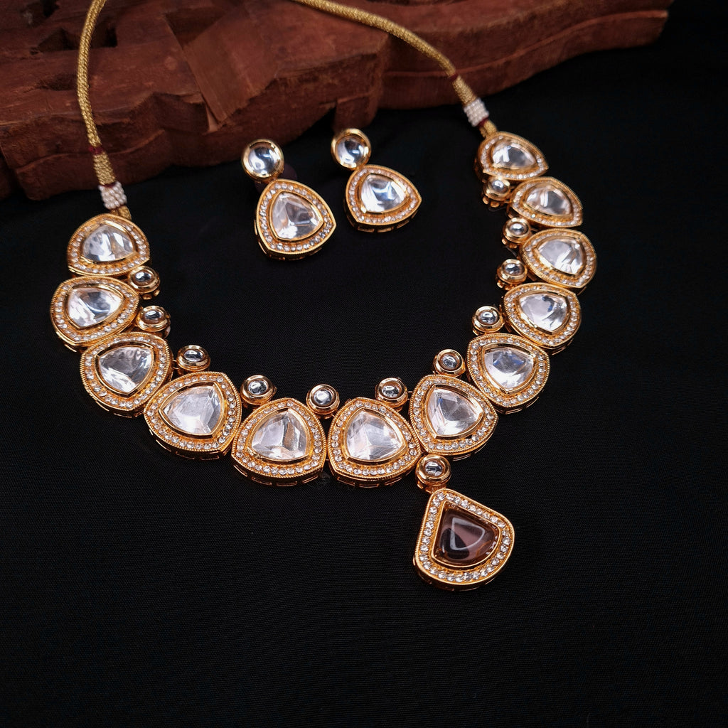 Uncut polki choker necklace set with pear-shaped stones and gold finish, paired with matching earrings

