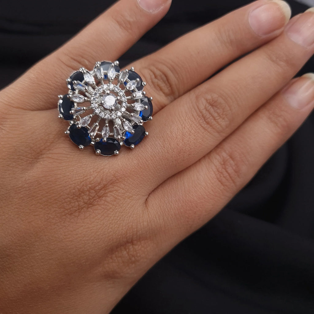 Silver CZ ring with blue center stone and diamond accents

