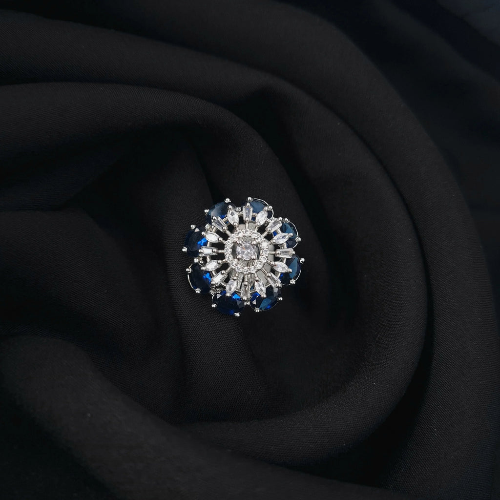 Silver CZ ring with blue center stone and diamond accents

