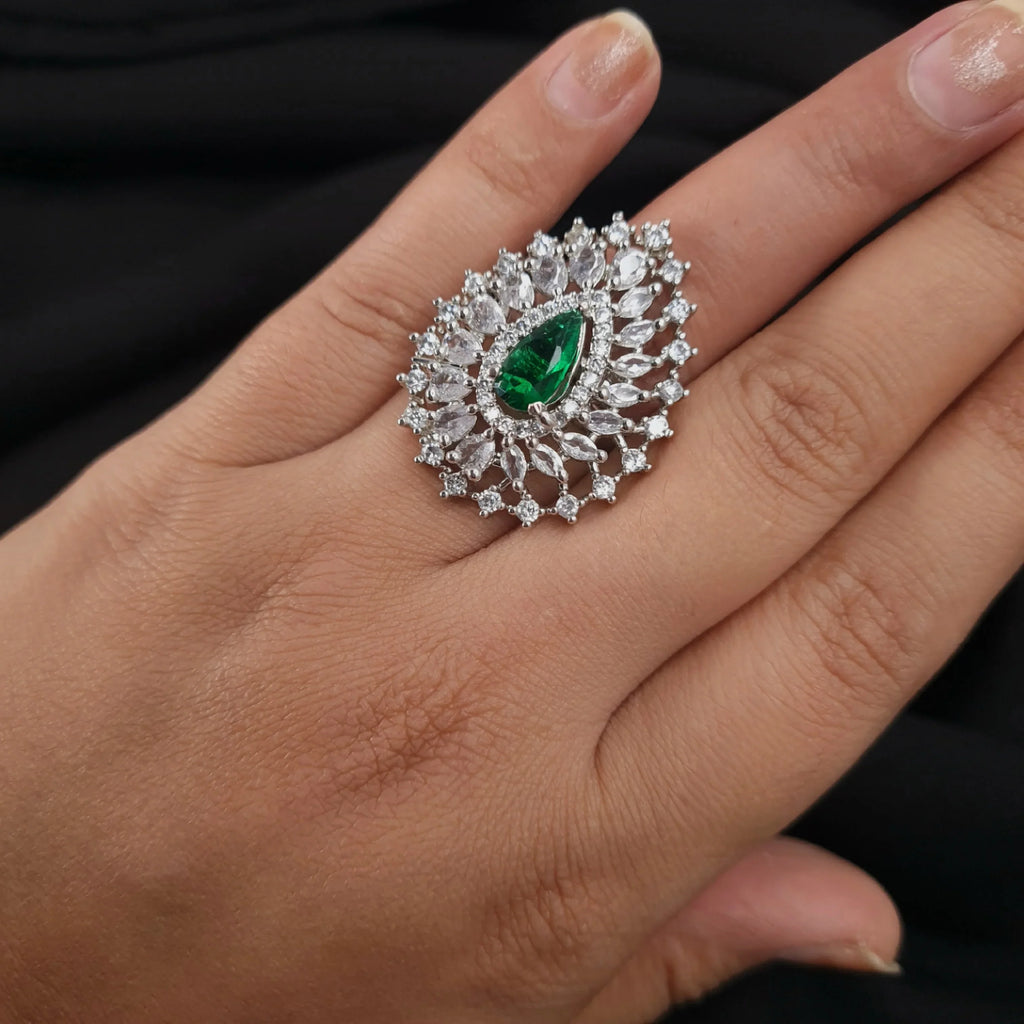 Silver AD ring with green emerald center and diamond accents

