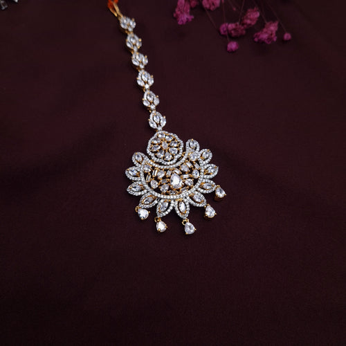 Traditional Kundan maangtikka displayed on velvet background with detailed floral design