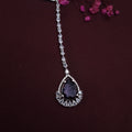 AD maangtikka with large dark purple stone and American Diamonds on white background