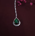 AD Maangtikka with large green center stone and American Diamonds on white background