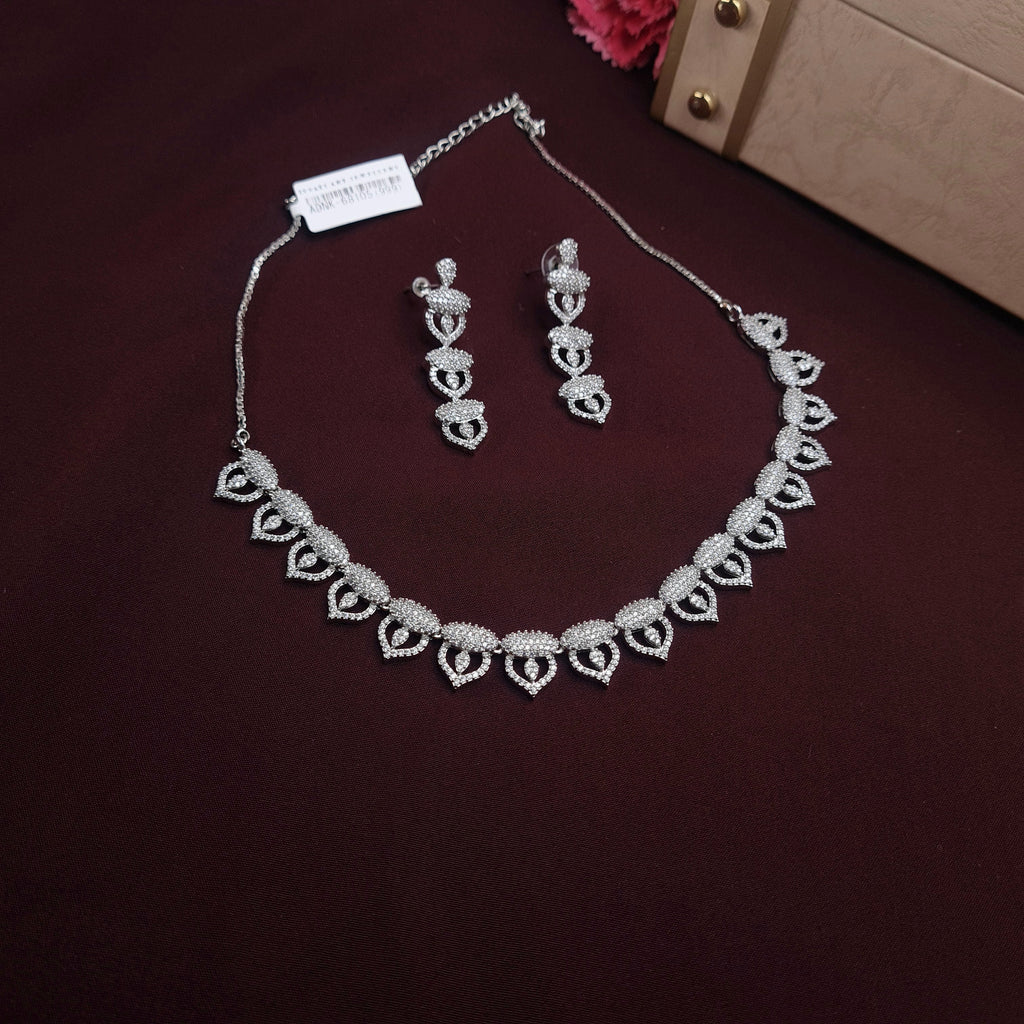 Silver-finished necklace and earrings set with leaf and teardrop design, studded with zirconia stones

