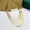 Three-layer gold snake chain necklace on white fabric background

